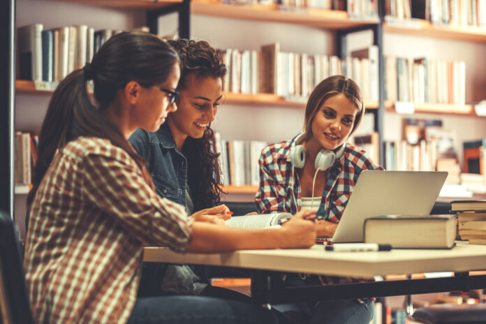 Group of female students study in the school library.Learning and preparing for university exam. Wymagania i predyspozycje na studia prawnicze. Jak wyglądają, czy są trudne i ile trwają